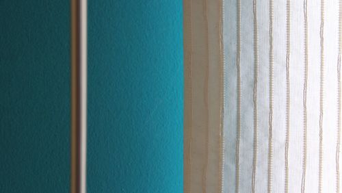 Rod and curtain against turquoise wall