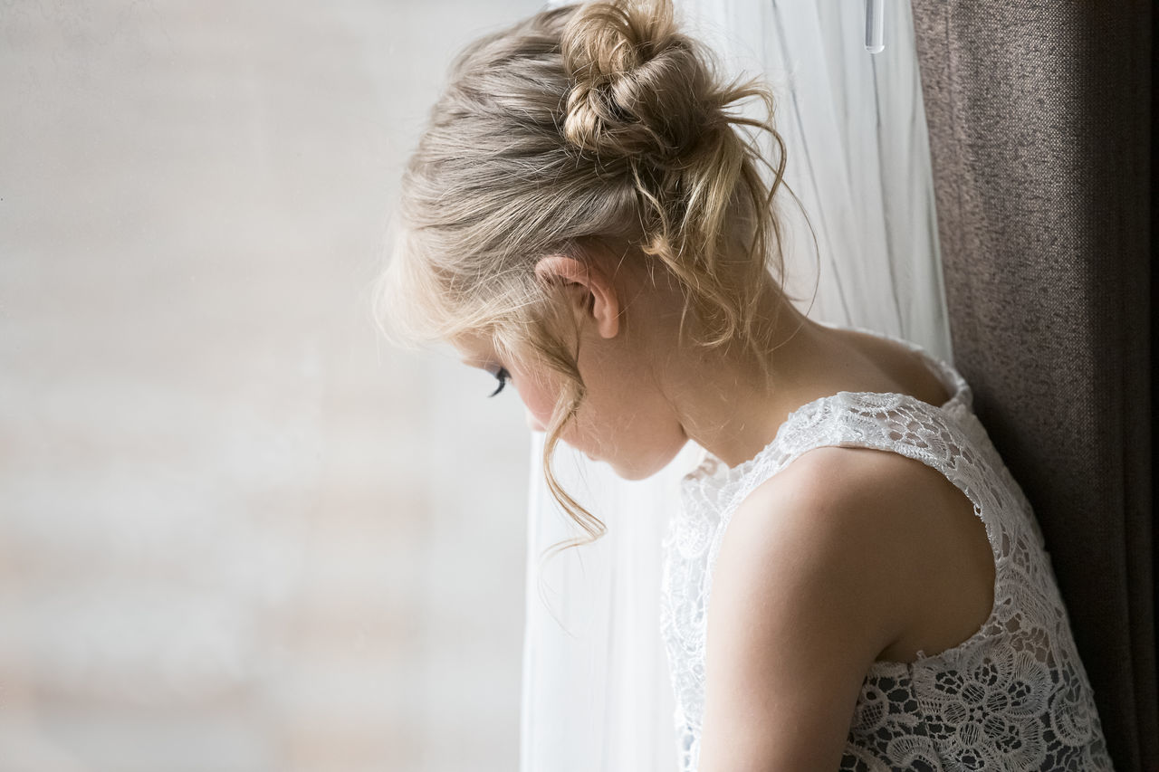 MIDSECTION OF WOMAN LOOKING AT WHITE HOME