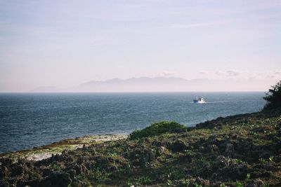 Scenic view of sea and mountains against sky