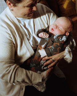 Grandmother holding newborn grandson 