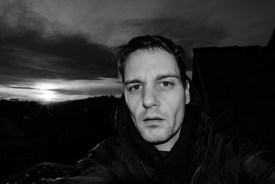 Portrait of young man looking away against sky