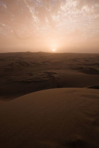 Scenic view of desert against sky during sunset