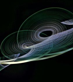Close-up of spiral illuminated against black background