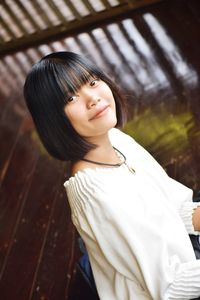 High angle portrait of smiling young woman on floor