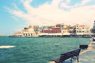 Buildings by sea against sky in city