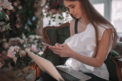 Midsection of woman using mobile phone outdoors