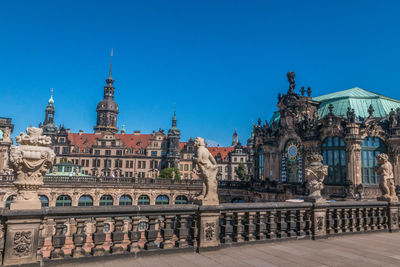 Buildings in city against clear blue sky