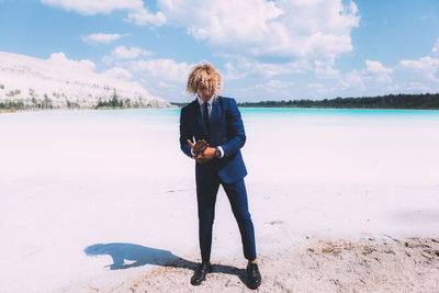 Full length of woman standing on beach against sky