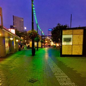 Empty road along buildings at night