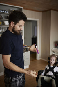 Father preparing nutrition for feeding tube for disabled child