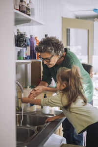 Side view of mother and daughter in kitchen