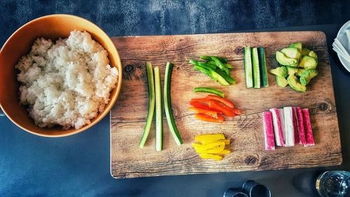 Raw vegetables with rice on cutting board