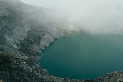 High angle view of volcanic mountain by sea