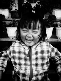 Happy girl against potted plants