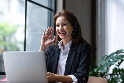 Portrait of smiling woman using mobile phone outdoors