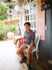 Young man looking away while sitting on chair