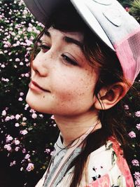 Close-up woman in cap by flowering plants