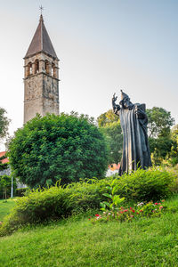 Low angle view of woman standing on grassy field against clear sky