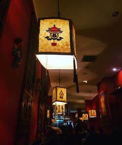 Low angle view of illuminated chandelier hanging on ceiling