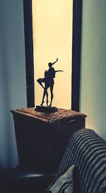 Silhouette statue with arms raised standing against sky