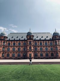 Man on field against building in city