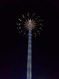 Low angle view of illuminated ferris wheel against sky at night