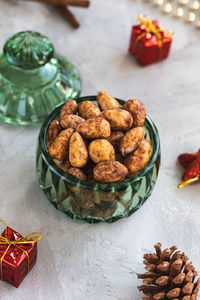 Candied or sugared almonds with honey and cinnamon in trendy green small glass jar