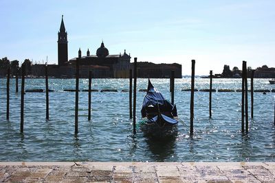 View of men on wooden post in canal