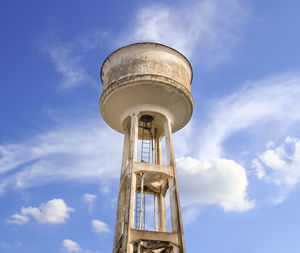 Water tower painted white under blue sky