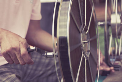 Midsection of man using film reel