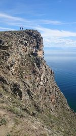 Scenic view of sea by cliff against sky