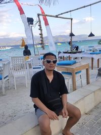 Portrait of young man sitting at beach