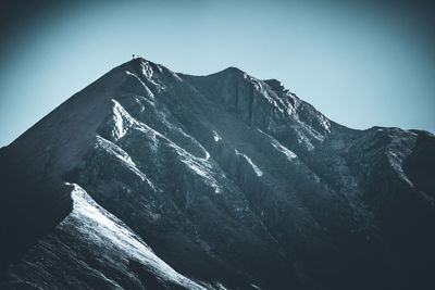 Low angle view of snowcapped mountain against clear sky