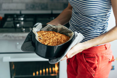 Midsection of woman holding food at home