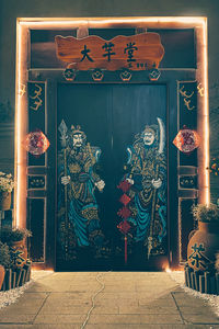 Illuminated text hanging on entrance of building