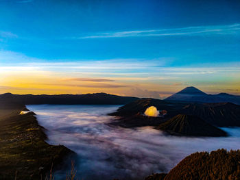 Scenic view of sea against cloudy sky during sunset