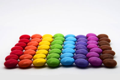 Close-up of multi colored candies against white background