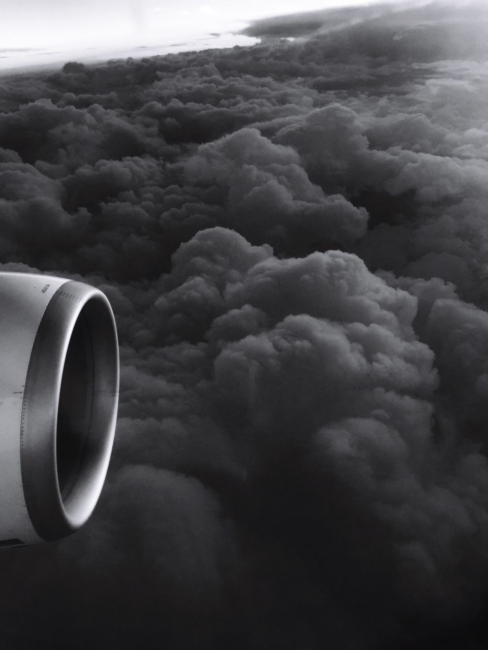 CLOSE-UP OF AIRPLANE FLYING OVER CLOUDS