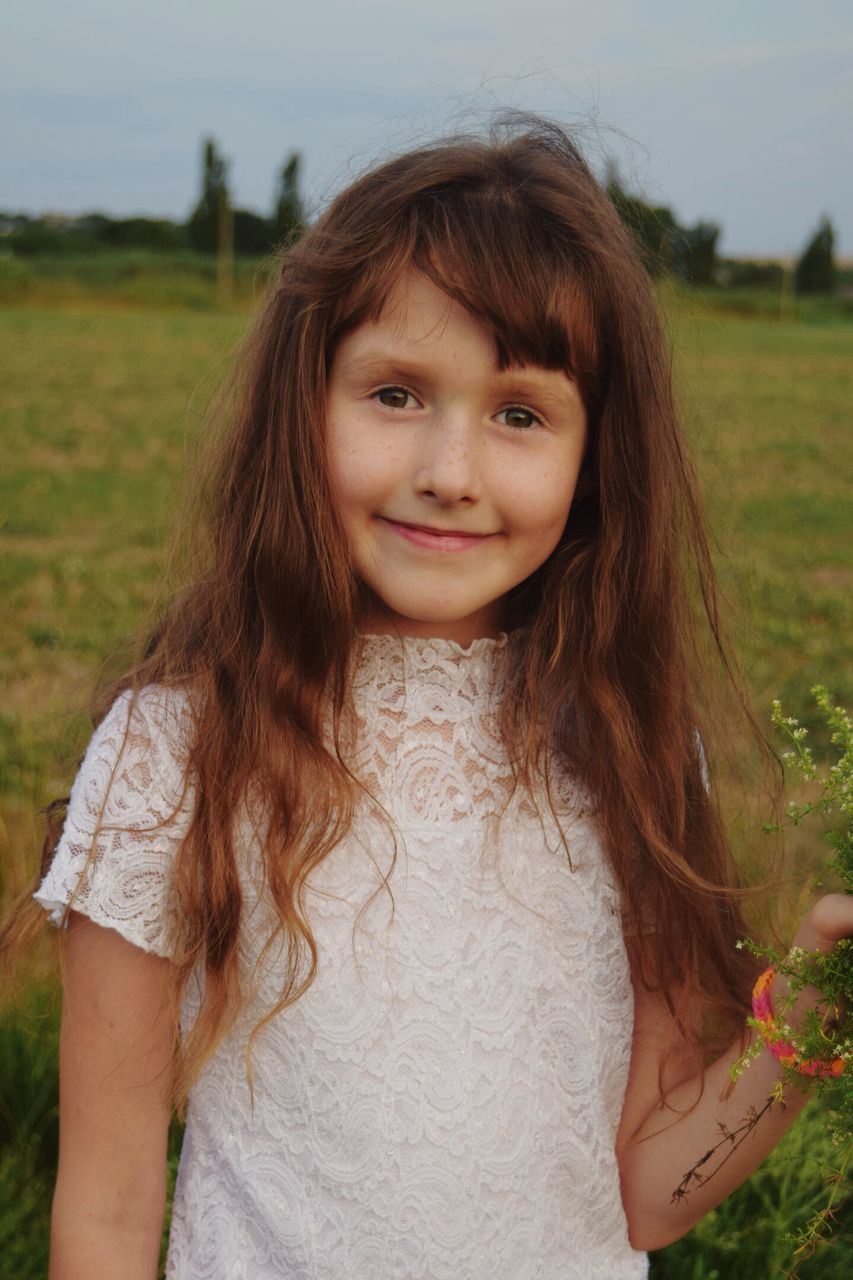 looking at camera, portrait, childhood, real people, focus on foreground, front view, smiling, field, one person, girls, standing, day, grass, outdoors, nature, close-up