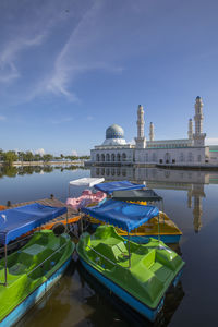 Boats moored at lake against sky