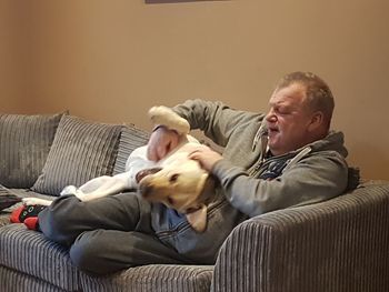 Man and dog on sofa at home