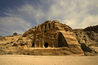 Petra tomb against cloudy sky