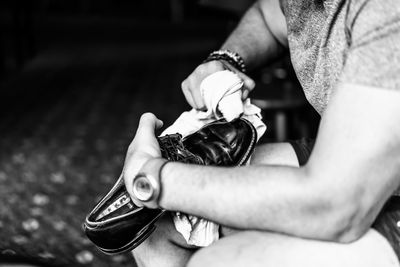 Midsection of man polishing shoe