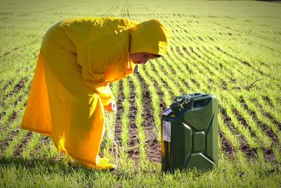 Side view of a boy on field with petrol tank climatic changes