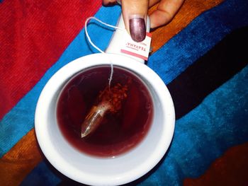 High angle view of hand holding tea cup on table