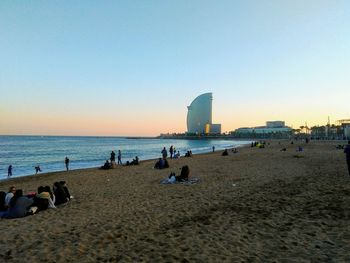 People on beach against clear sky
