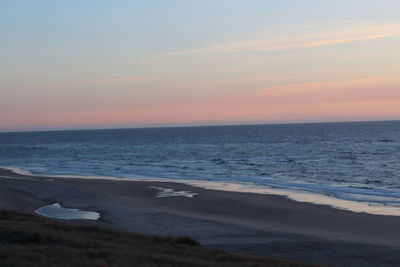 Scenic view of beach against sky during sunset