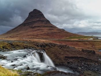 Scenic view of waterfall against sky