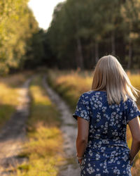 Rear view of woman standing against trees