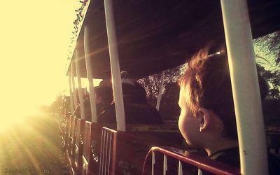 Woman with arms raised against sky during sunset